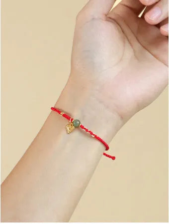 Handmade women's bracelet with 925 silver and Hetian jade in woven design with red carrying strap