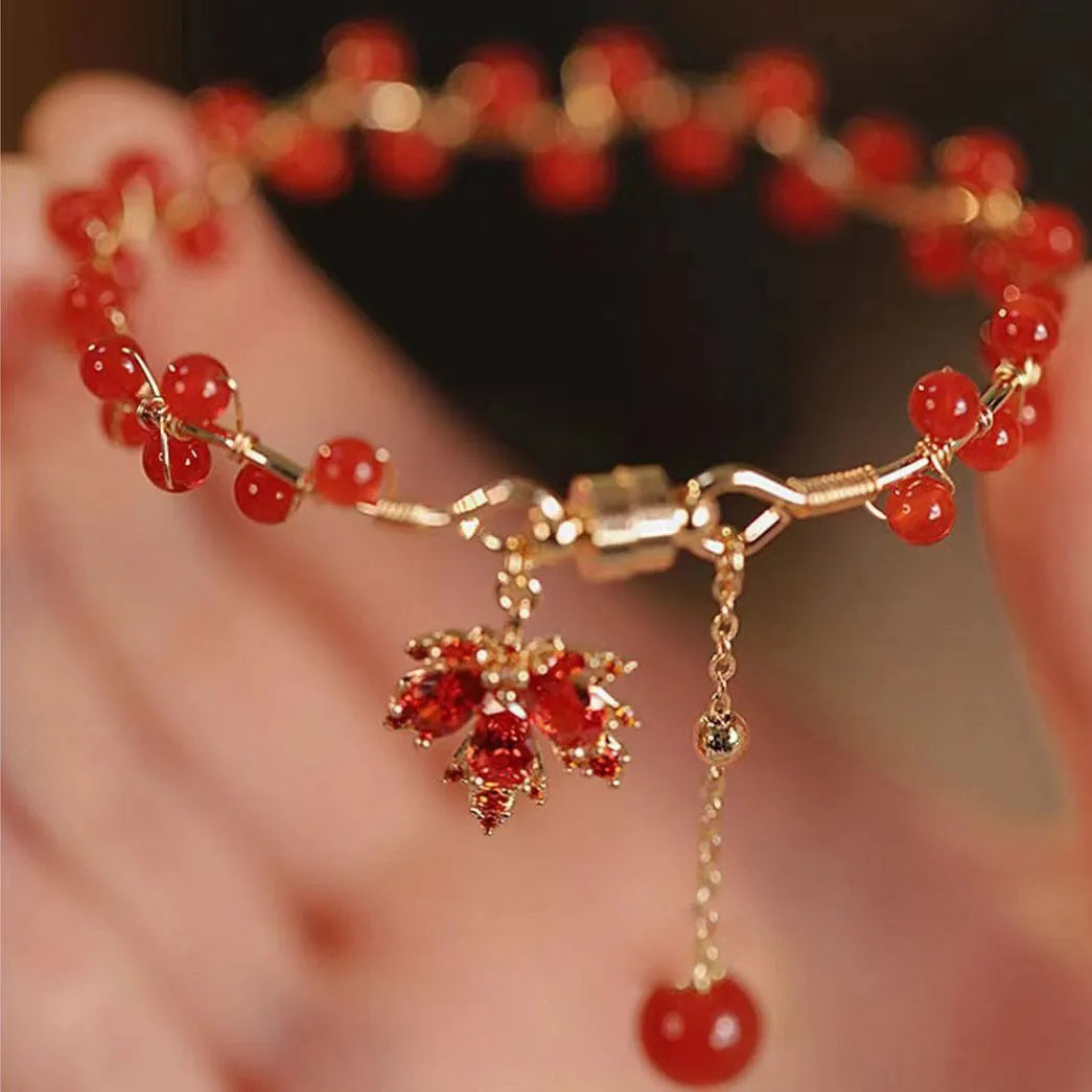 Red ginkgo leaf charm magnetic bracelet for girls on a wrist, showing maple leaf design details.