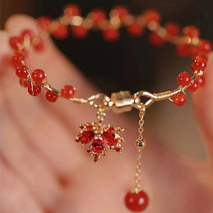 Red ginkgo leaf charm magnetic bracelet for girls on a wrist, showing maple leaf design details.