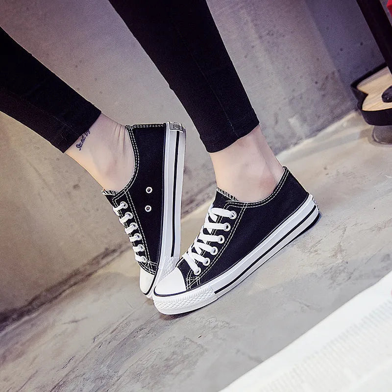 Women's solid-colour canvas casual shoes in black, shown from the side.