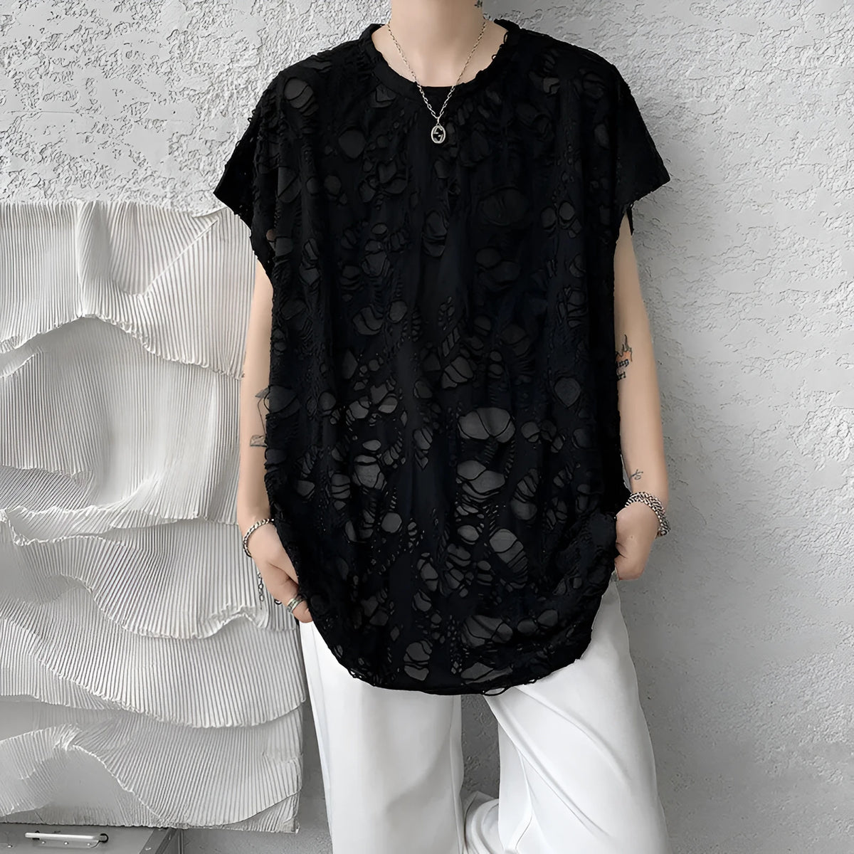 Black loose-fit sleeveless vest with ripped detail and wide shoulders, showcasing Japanese retro style.