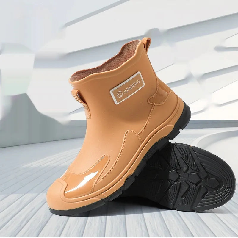 Minimalist black PVC waterproof wading boots with flat heel and round toe on a neutral background.