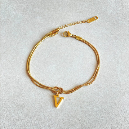 Elegant letter charm bracelets for women in gold and silver tones, featuring a delicate snake chain design and personalised letter charms.