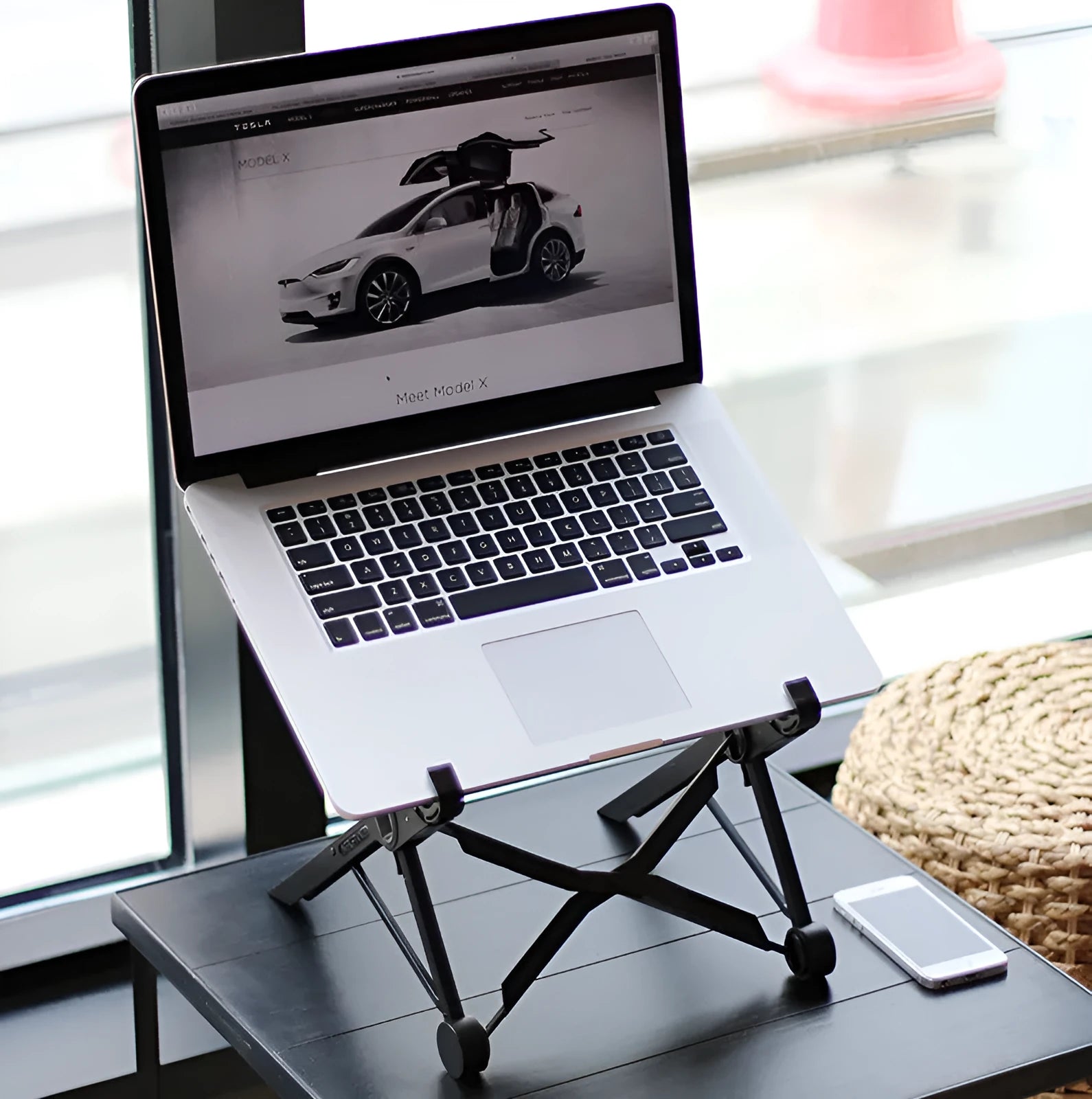 Black reinforced nylon folding laptop stand shown in open and closed positions on a wooden desk.