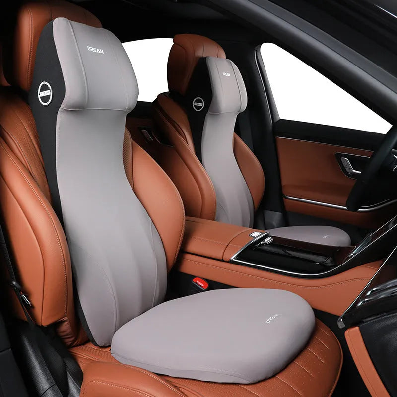 Black memory foam automotive waist cushion and matching headrest pillow set on a car seat.