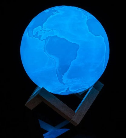 3D printed white moon lamp on a wooden holder, showing detailed crater texture and soft LED glow.