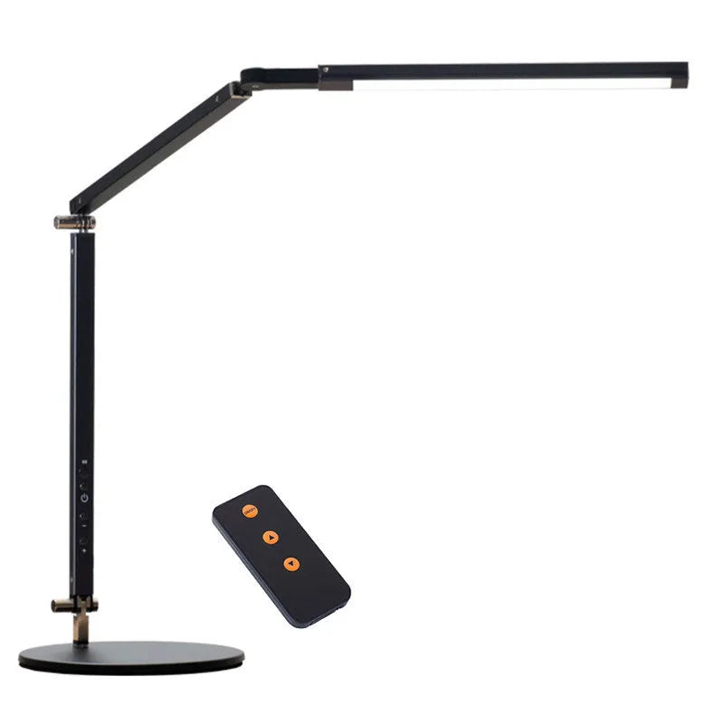 Adjustable aluminium desk lamp with remote control, shown in black with a clip attached to a desk edge.