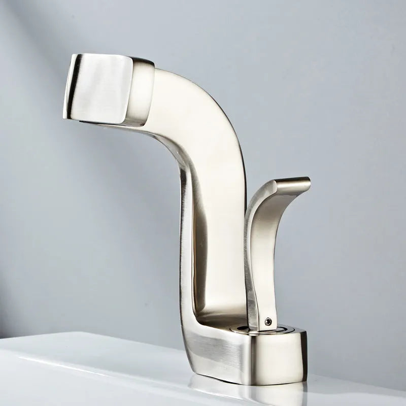 Copper vanity basin mixer tap with lift handle, shown in black and gold finish.