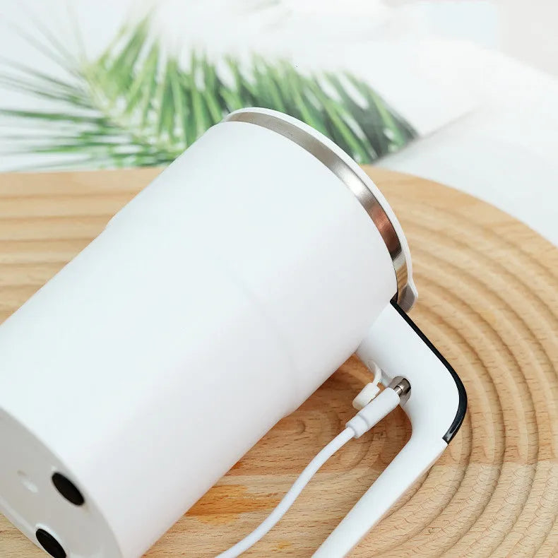 Electric coffee mug with USB charging port, magnetic stirrer, and LCD display showing temperature, in black or white colour.