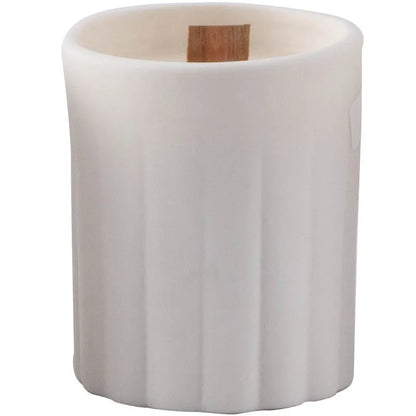 Set of ten round white ceramic candlesticks with minimalist relief patterns on a dining table