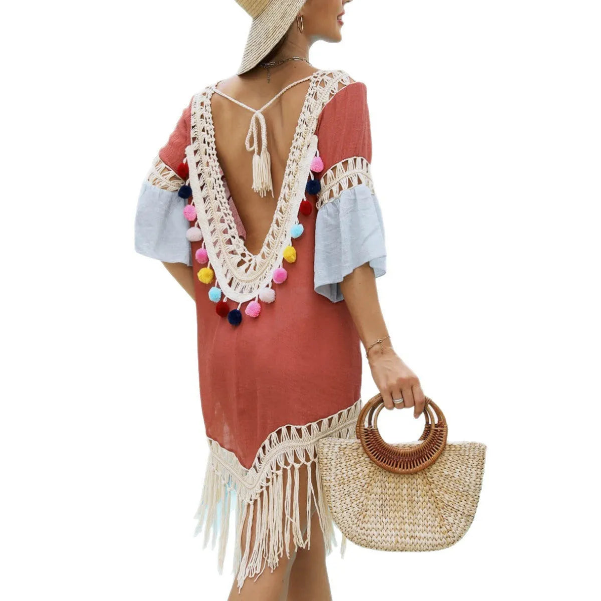 Orange floral print beach overskirt with hand-crochet detail and tassel trim, worn as a cover-up over swimwear.