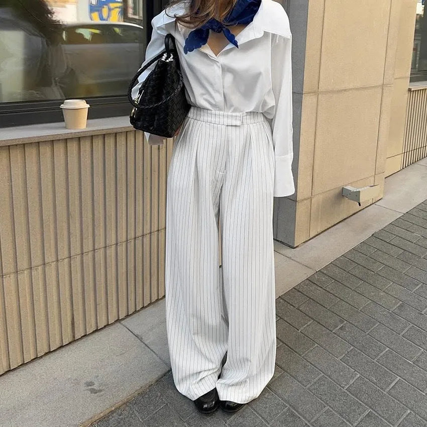 White women's wide-leg trousers with a striped pattern and zip detail, laid flat.