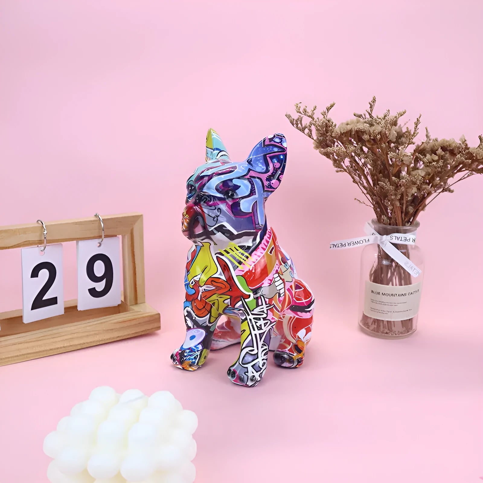 Colourful graffiti-style French bulldog resin statue on a white background