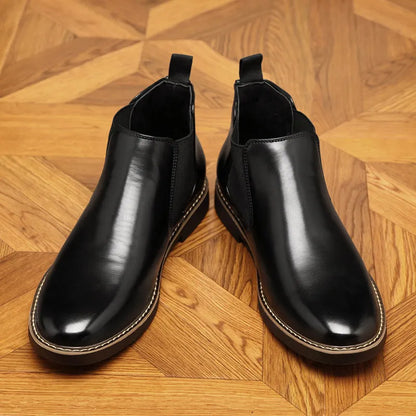 A pair of formal black leather pointed-toe boots with a square heel and rubber sole