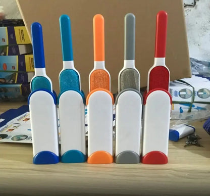 Blue reusable pet hair removal brush with double-sided head next to its self-cleaning base.