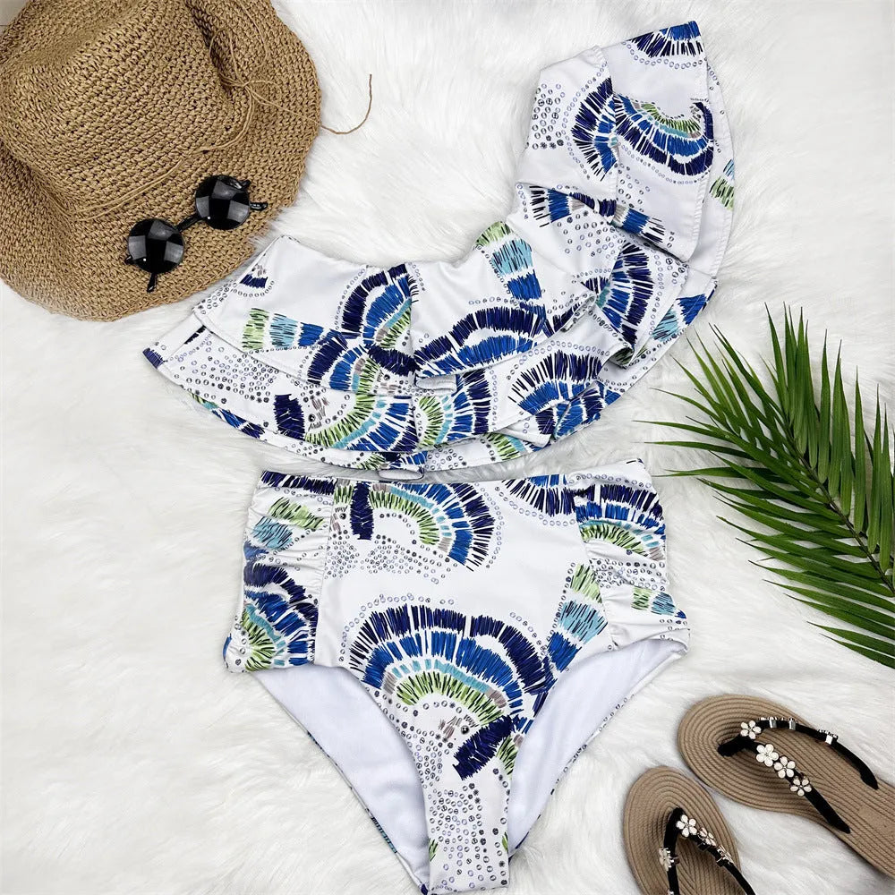 White women's one-shoulder swimsuit with draped lotus leaf design and high-leg split on a model