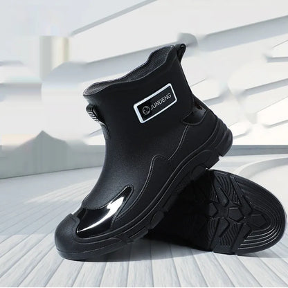 Minimalist black PVC waterproof wading boots with flat heel and round toe on a neutral background.