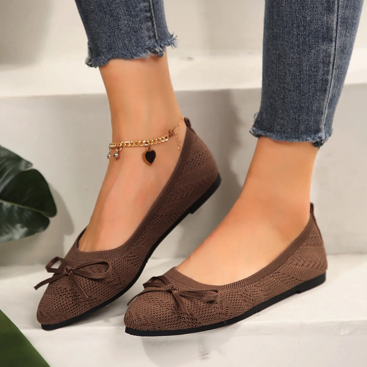 Women's blue knitted loafer flat shoes with a pointed toe and decorative bow detail on the front.