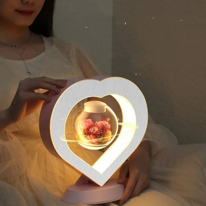 Pink rose eternal flower floating in magnetic levitation LED night light with triangular base and touch control