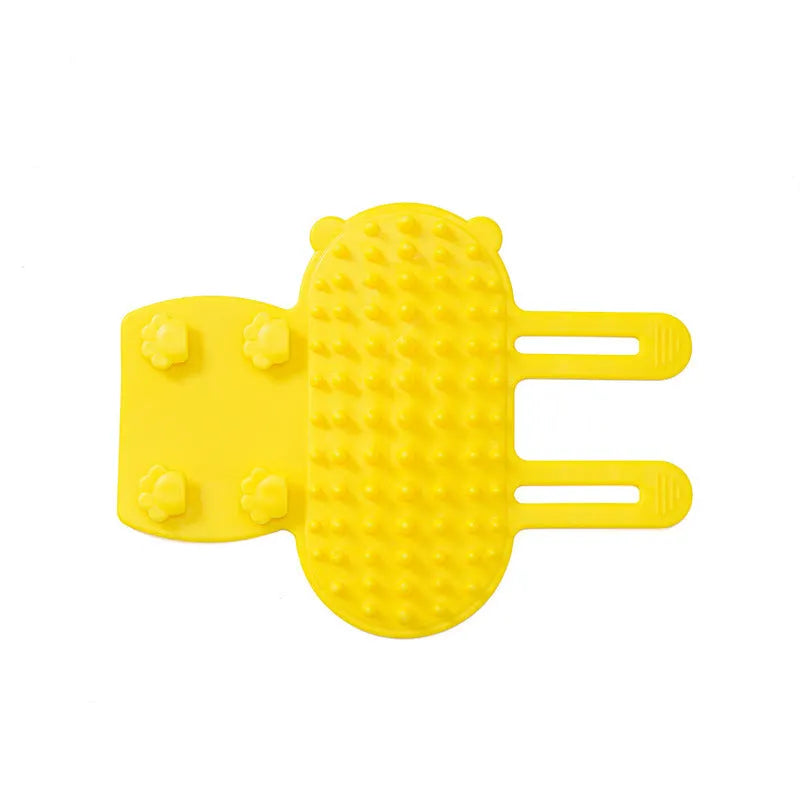 Silicone cat grooming comb with adjustable strap mounted on a table leg, shown in green.