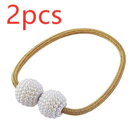 Magnetic curtain tiebacks with white pearl beads and fabric loops holding gathered curtain