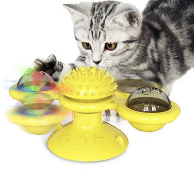 Cat playing with rotating windmill toy featuring luminous balls and suction base
