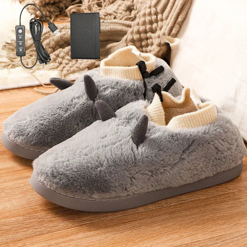 USB heating slippers in black plugged into a laptop, showing the cable and soft velvet upper.