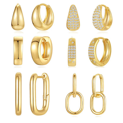 Pair of golden geometric clip-on earrings with a round design and screw-back mechanism on a white background.