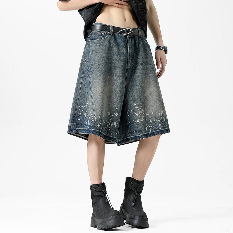 Men's denim shorts with retro blue wash, ripped distressing, and splash ink detailing in a straight-leg cut, featuring a fifth-pants length mid-thigh style, inelastic fabric construction, available in six sizes from S to 3XL for a classic casual look.