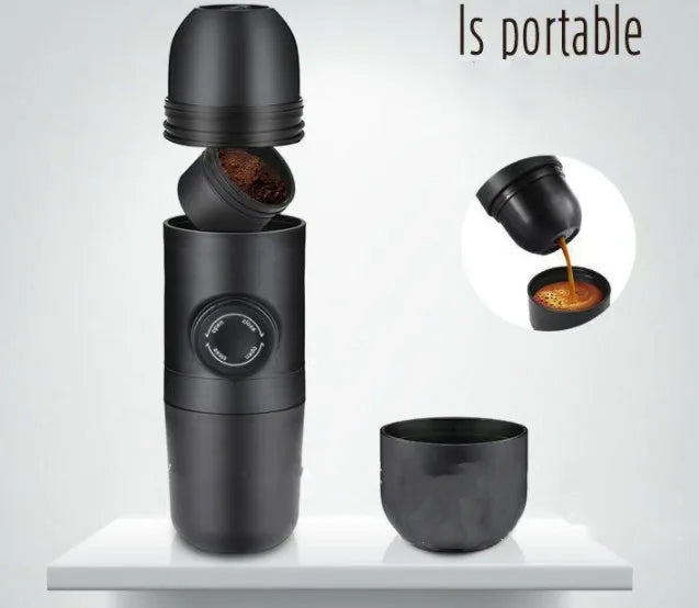 Black portable manual espresso maker with stainless steel parts, shown next to a coffee bag and mug.