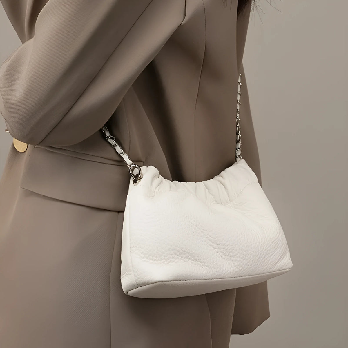Women's dumpling-shaped genuine leather crossbody bag in three neutral colours showing slit pocket