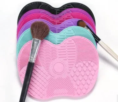 Silicone makeup brush cleaning pad, 15.5 x 12 cm, shown as a coloured brush cleaner mat for cleansing makeup brushes.