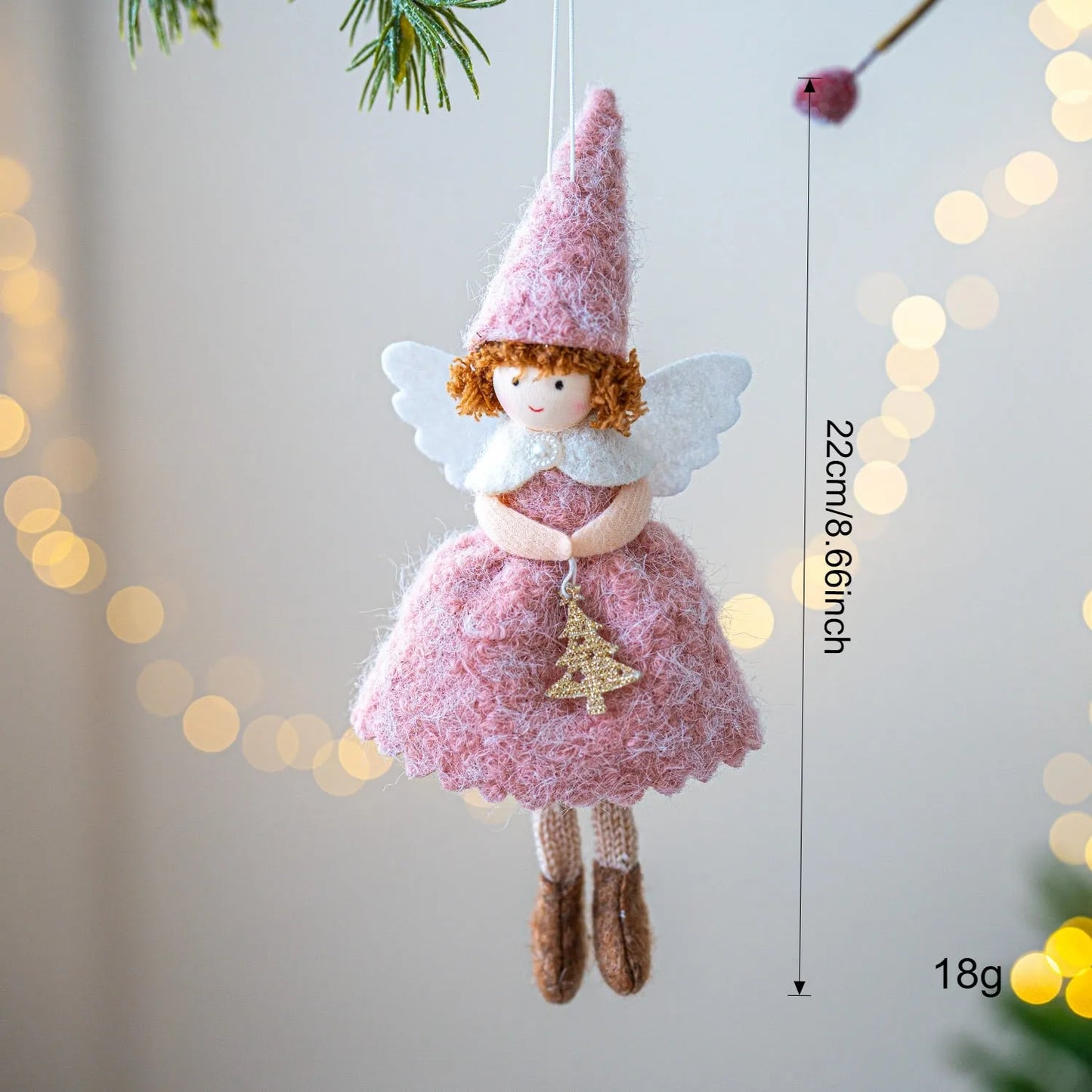 White and pink cloth felt Christmas angel skirt pendant ornament on a tree branch.