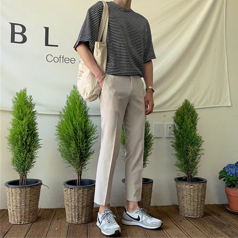 Man wearing black slim straight-leg loose fit cotton trousers with a drawstring waist