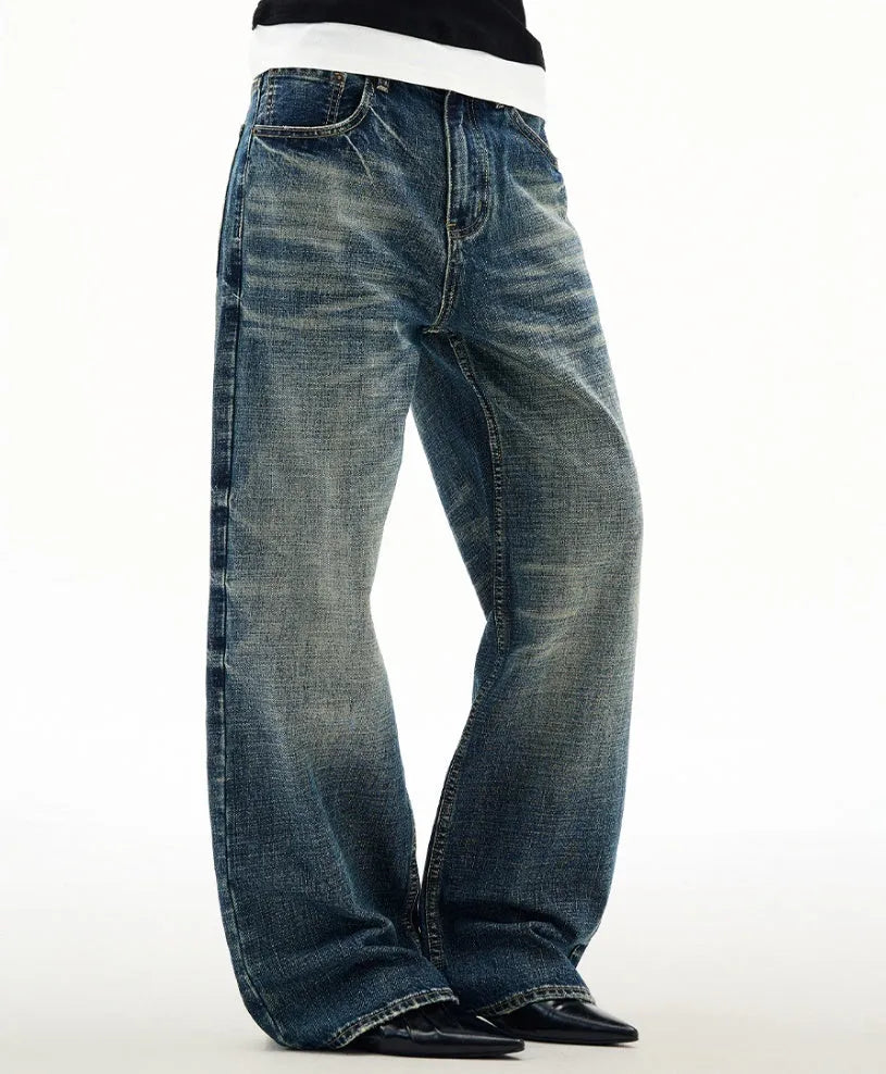 Men's wide leg mid waist jeans in dark blue denim with straight loose cut and distressed cat beard detail