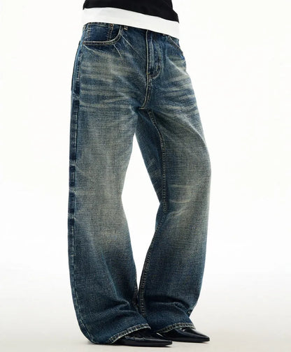 Men's wide leg mid waist jeans in dark blue denim with straight loose cut and distressed cat beard detail