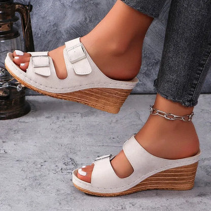 Women's creamy-white outer wedge beach slippers with a belt buckle detail on the strap.