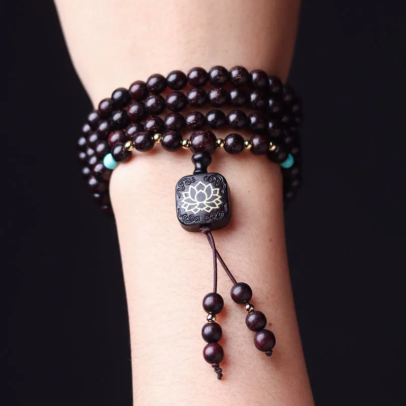 Zambia rosewood bead bracelet with 108 beads and flat lotus pendant on wooden surface