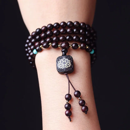 Zambia rosewood bead bracelet with 108 beads and flat lotus pendant on wooden surface