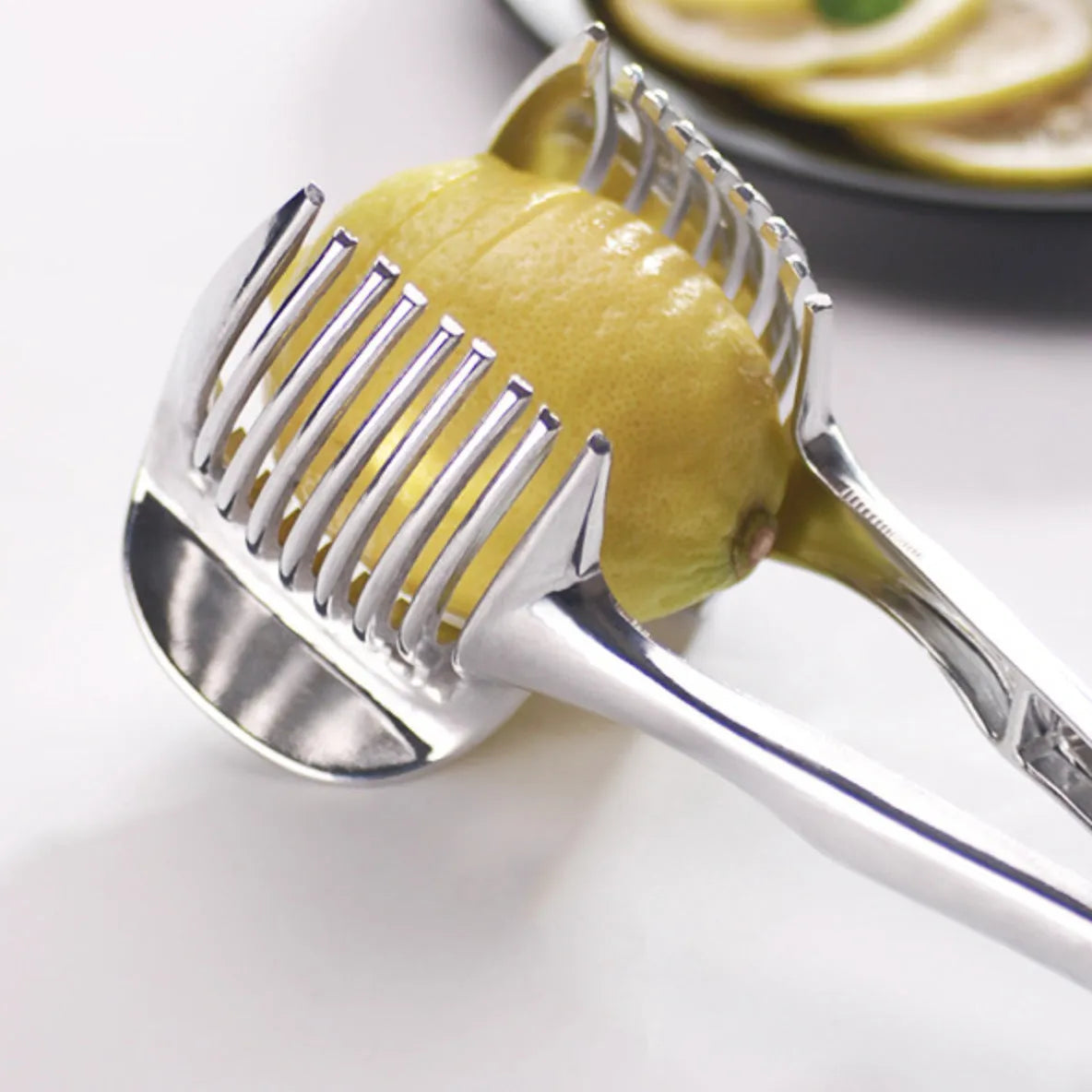 Silver plastic foldable lemon slicer kitchen gadget on a white background.