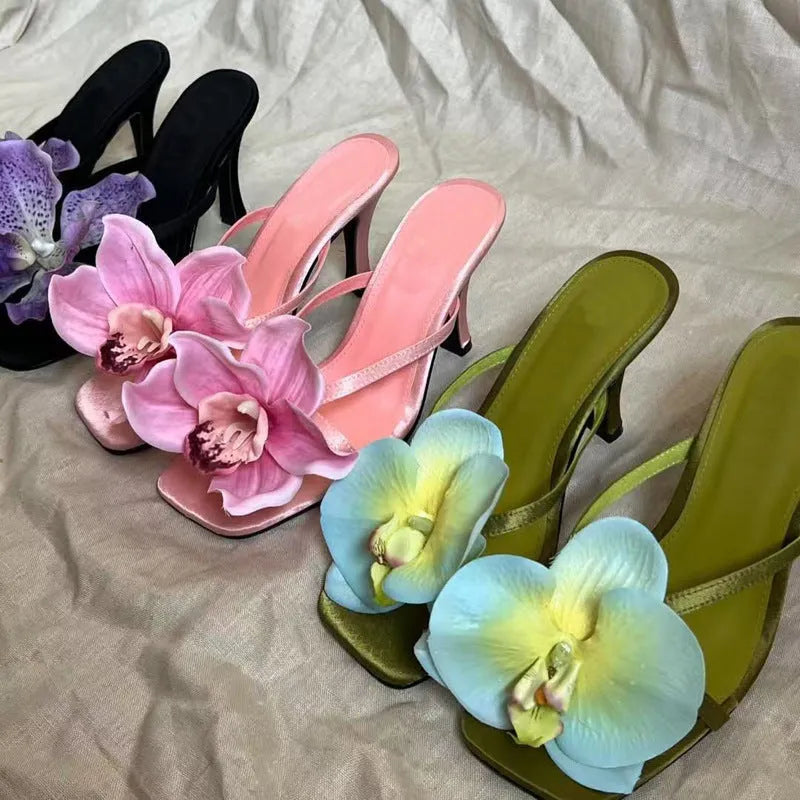 Women's artificial flower sandals in pink satin with mid-heel design and square toe, a pair of flip-flop style high heel sandals featuring Phalaenopsis orchid detailing for casual or event wear, available in UK sizes 3 to 7.