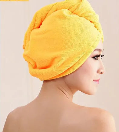 A woman wearing a sky blue microfiber hair dryer cap, with wet hair tucked inside, showing the towel's wrap-around design.