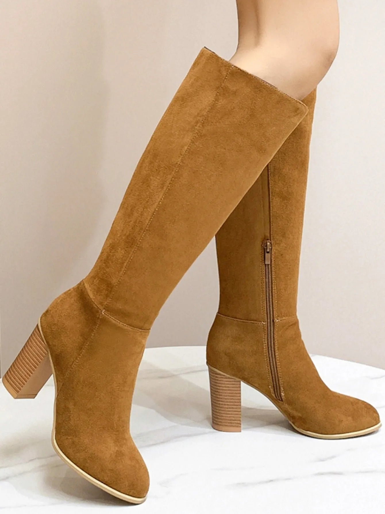 Black square toe high heel fashion boots for women on a neutral background