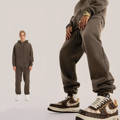 Man wearing solid colour cotton velvet sweatpants with an ankle banded design in a dark grey shade.