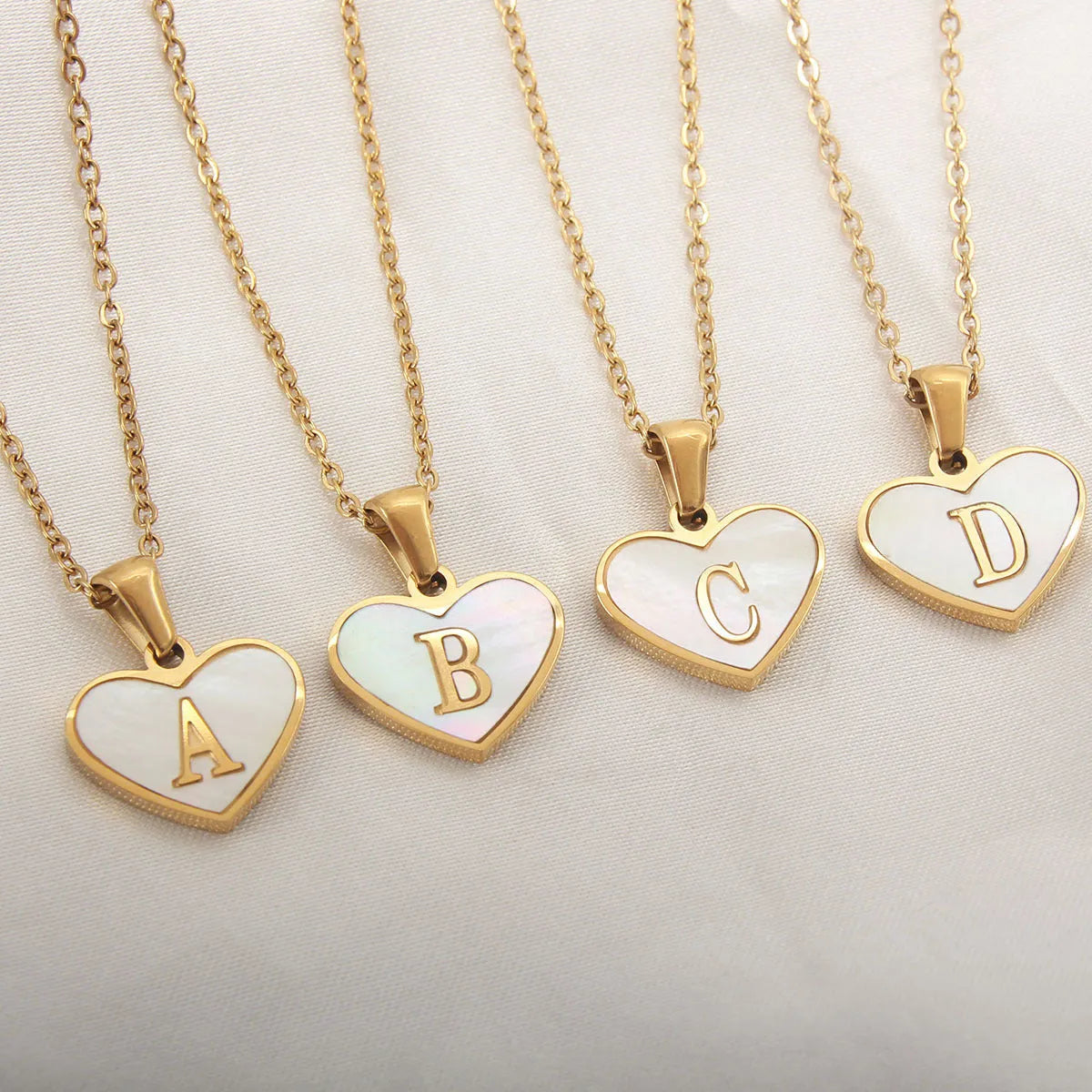 Gold-plated heart necklace with white shell pendant showing letter personalisation option