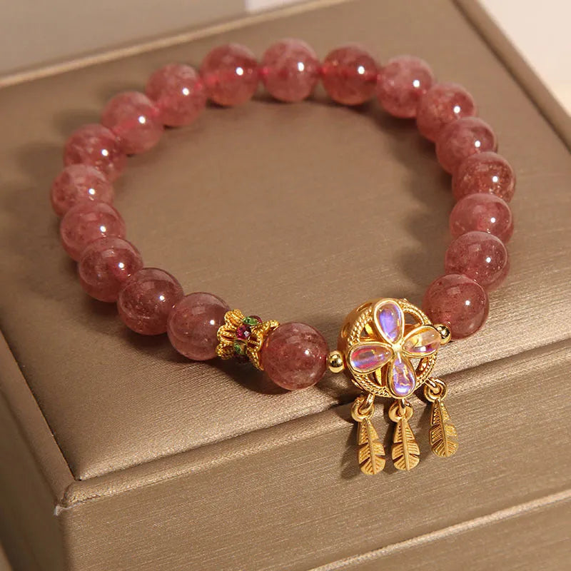 Women's strawberry quartz crystal bracelet with a four-leaf clover dream catcher pendant.