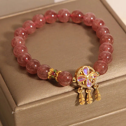 Women's strawberry quartz crystal bracelet with a four-leaf clover dream catcher pendant.