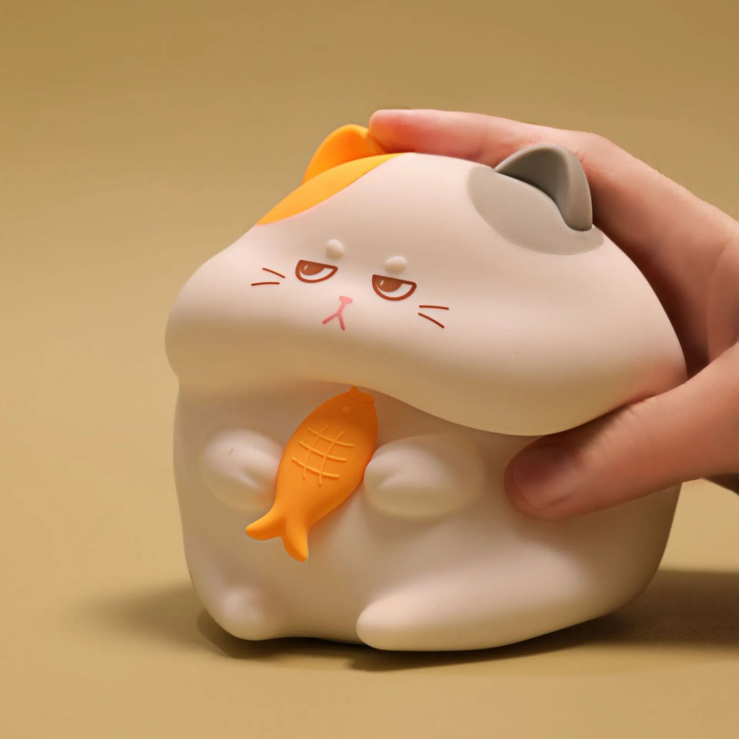 Yellow cartoon Greedy Cat desktop night light with plug, shown on a wooden desk.