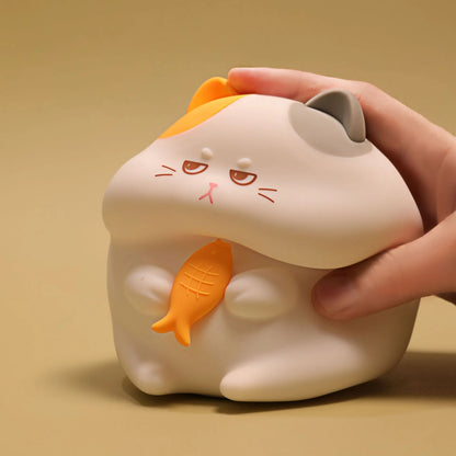 Yellow cartoon Greedy Cat desktop night light with plug, shown on a wooden desk.