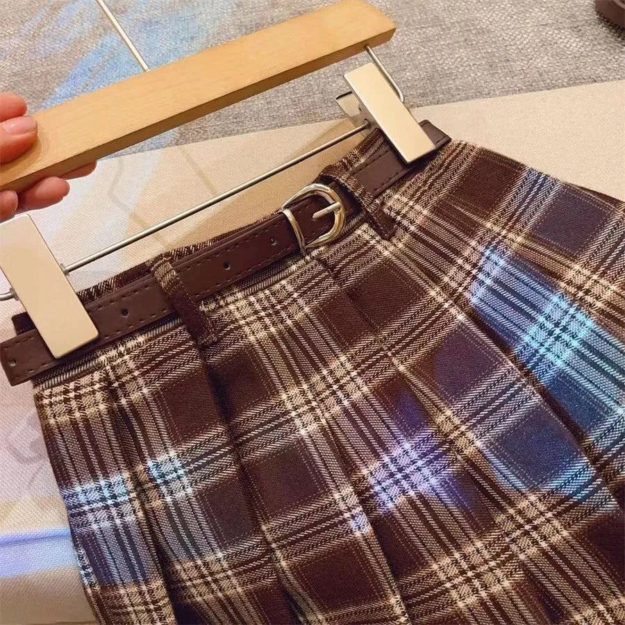 Girls' plaid pleated A-line skirt in cotton blend fabric, shown on a hanger.